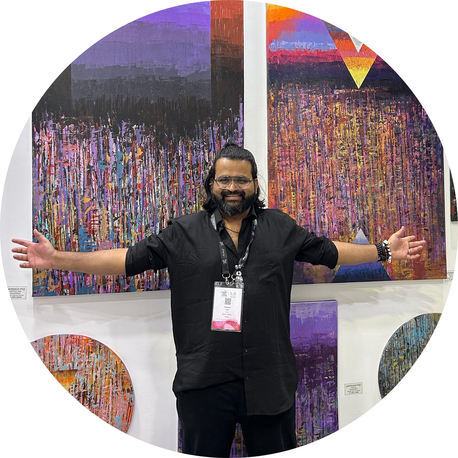 Indian abstract artist avinash pise at the exhibition, standing in front of his artworks