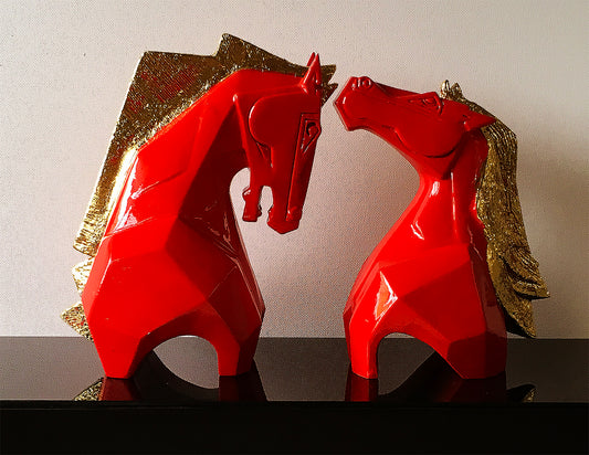 High-gloss red fiberglass sculpture of two stylized horses with textured gold manes, titled 'Caressing' by Dinkar Jadhav.