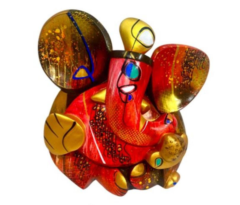 A colorful contemporary fiberglass sculpture of Lord Ganesha by Om Swami titled Agrapujyay, featuring intricate patterns in red, orange, and gold.