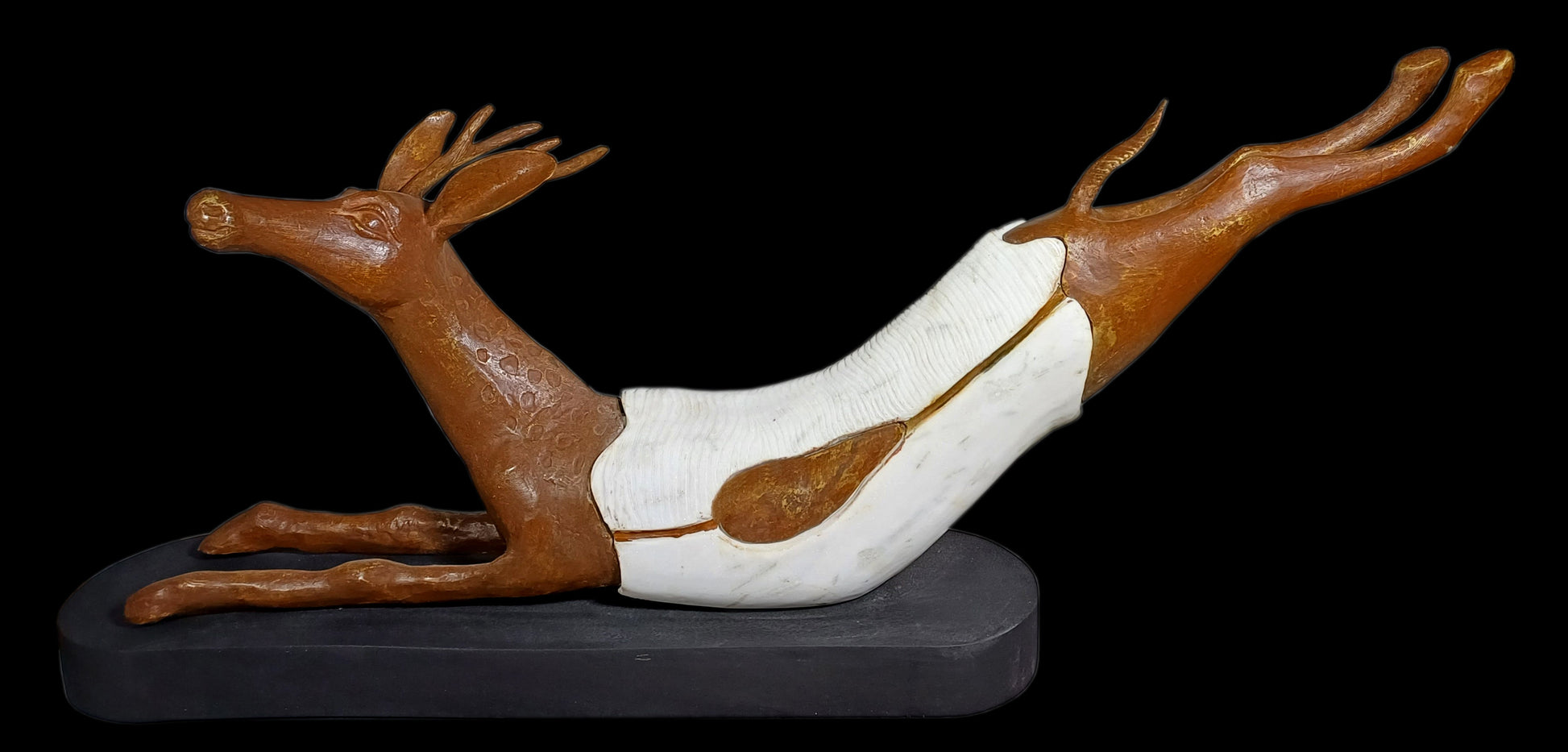 Subrata Paul contemporary horizontal bronze and white marble sculpture titled Speed depicting a leaping deer on a dark stylized base